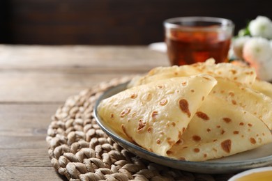 Photo of Delicious crepes on wooden table, closeup. Space for text