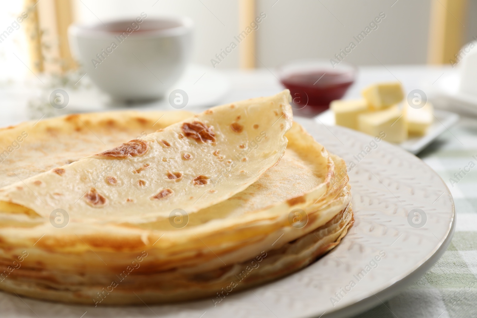 Photo of Stack of delicious crepes on table, closeup