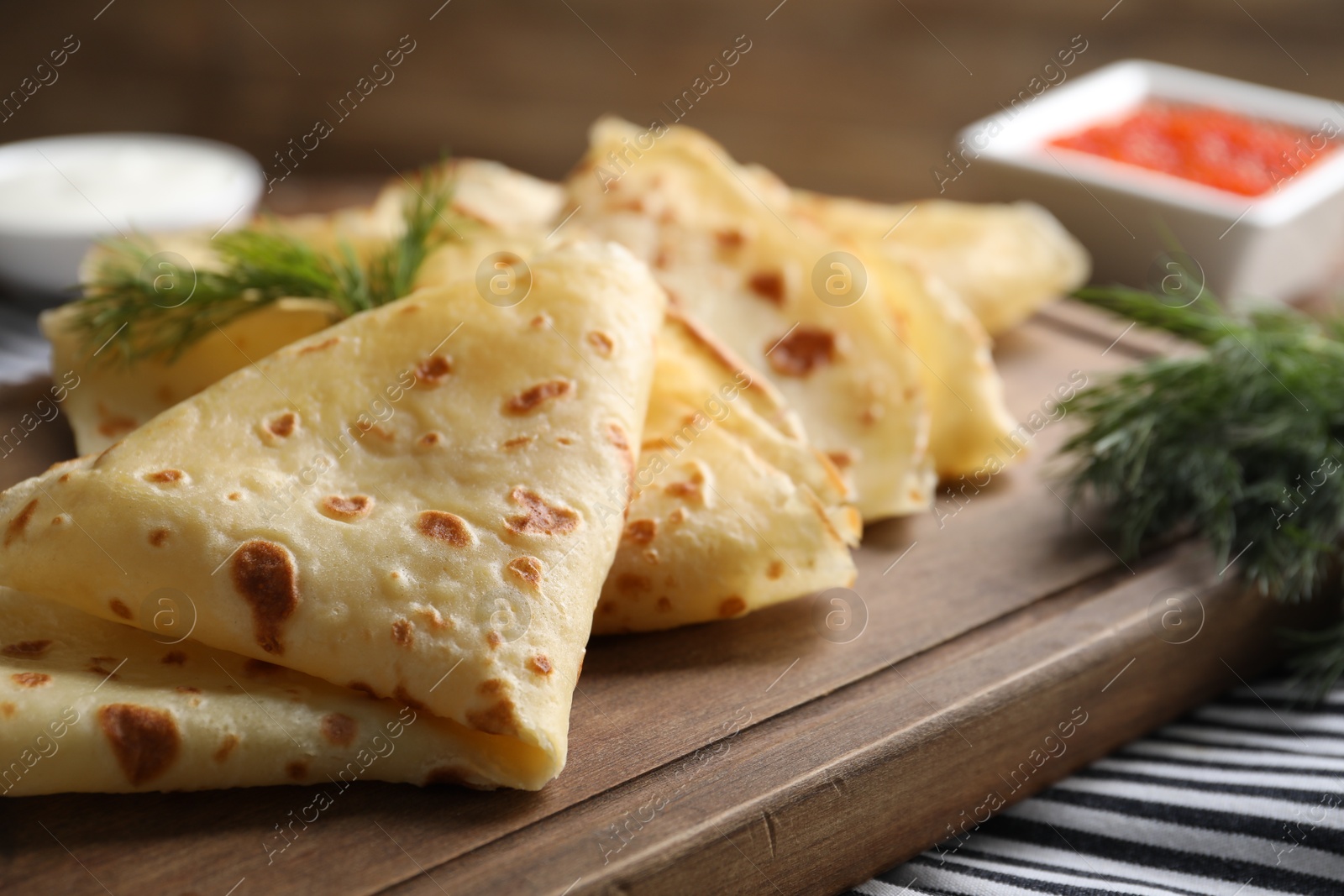 Photo of Delicious crepes and dill on table, closeup