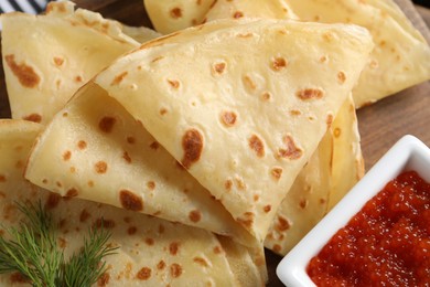 Photo of Delicious crepes and red caviar on table, top view