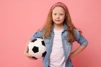 Photo of Little girl with soccer ball on pink background