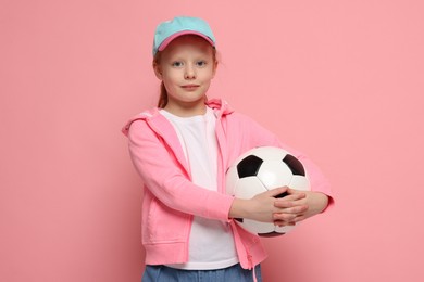 Photo of Little girl with soccer ball on pink background