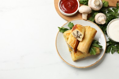 Photo of Delicious rolled crepes with mushrooms, parsley, ketchup and sour cream on white marble table, flat lay. Space for text