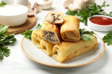 Photo of Delicious rolled crepes with mushrooms, parsley, sauce and sour cream on white marble table, closeup