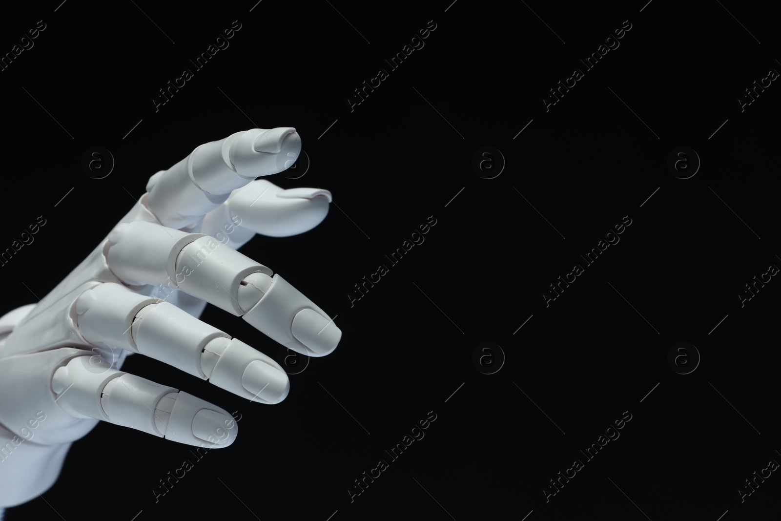 Photo of Artificial intelligence. Robot hand gesturing on black background, space for text