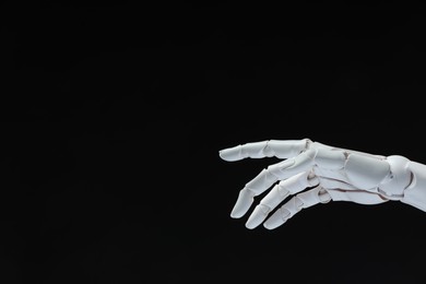 Photo of Artificial intelligence. Robot hand gesturing on black background, space for text