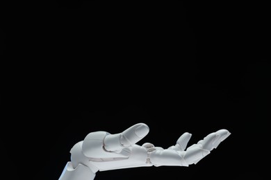 Photo of Artificial intelligence. Robot hand gesturing on black background, space for text