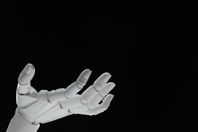 Photo of Artificial intelligence. Robot hand gesturing on black background, space for text