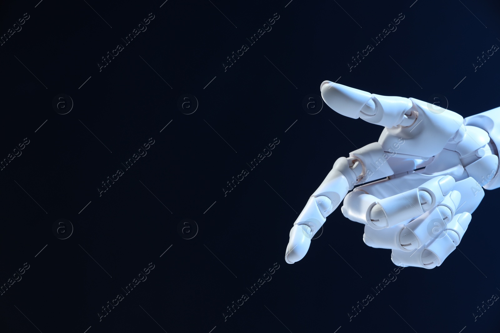 Photo of Artificial intelligence. Robot hand pointing at something on dark blue background, space for text