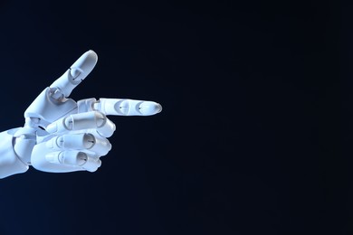 Photo of Artificial intelligence. Robot hand pointing at something on dark blue background, space for text