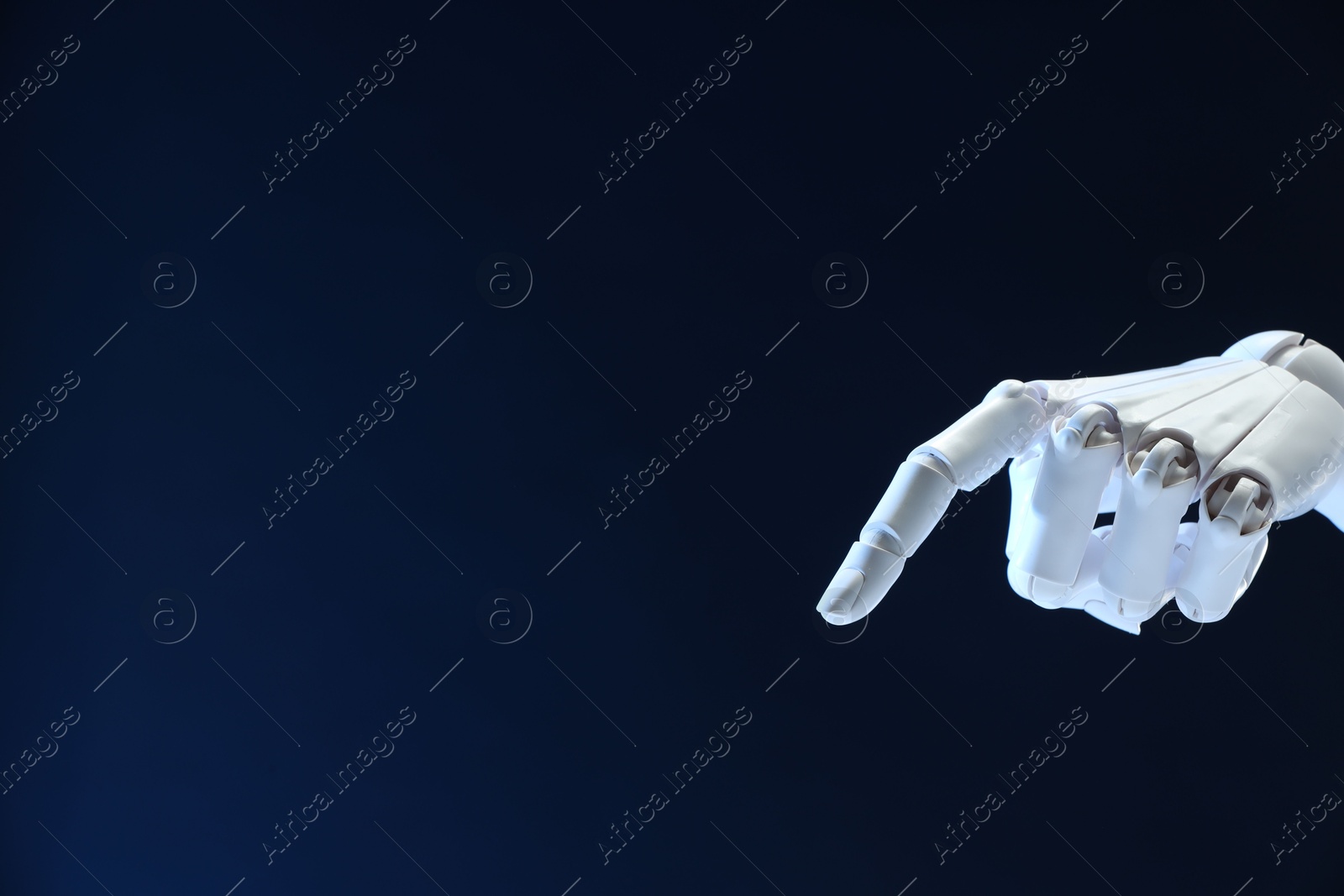 Photo of Artificial intelligence. Robot hand pointing at something on dark blue background, space for text