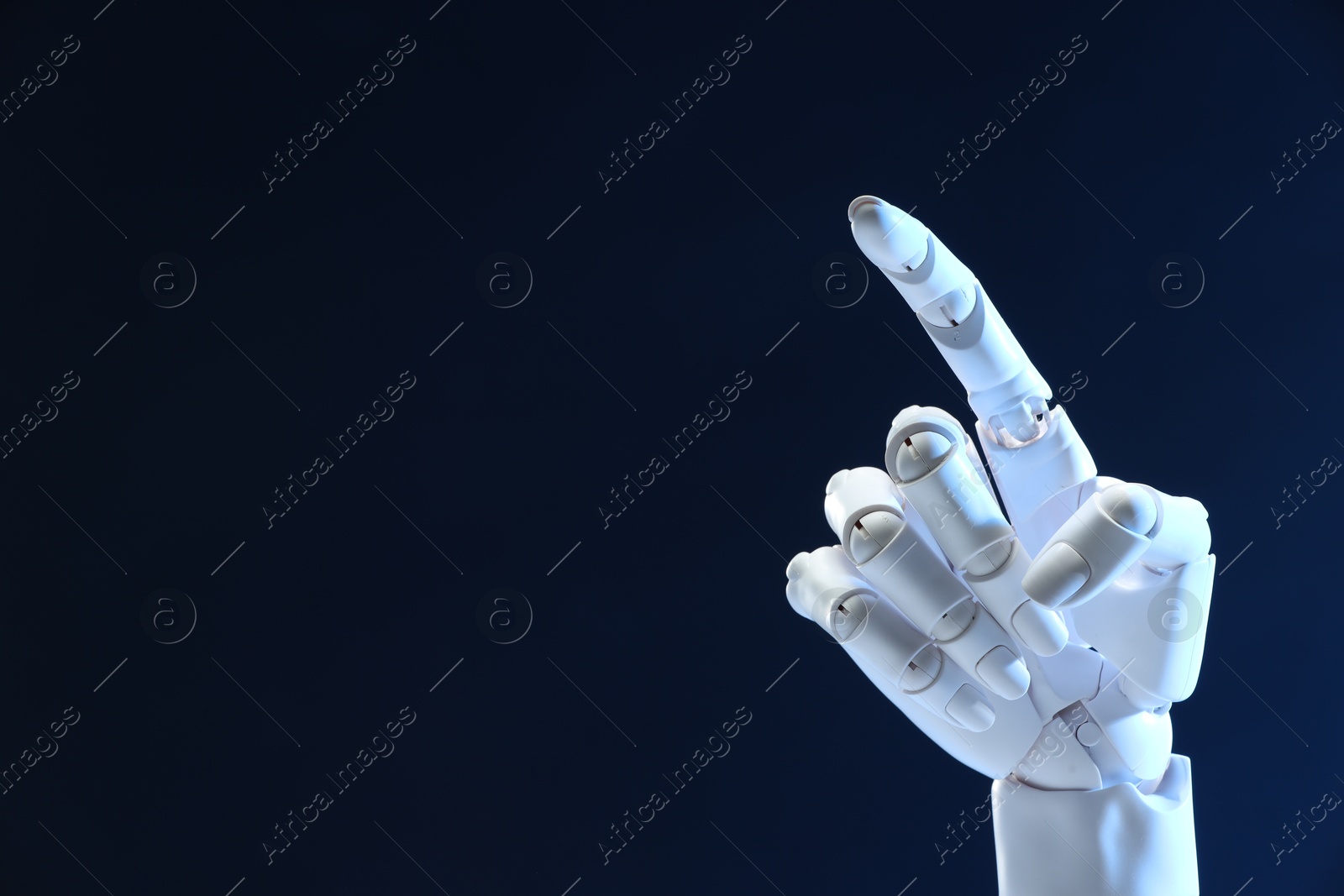 Photo of Artificial intelligence. Robot hand pointing at something on dark blue background, space for text