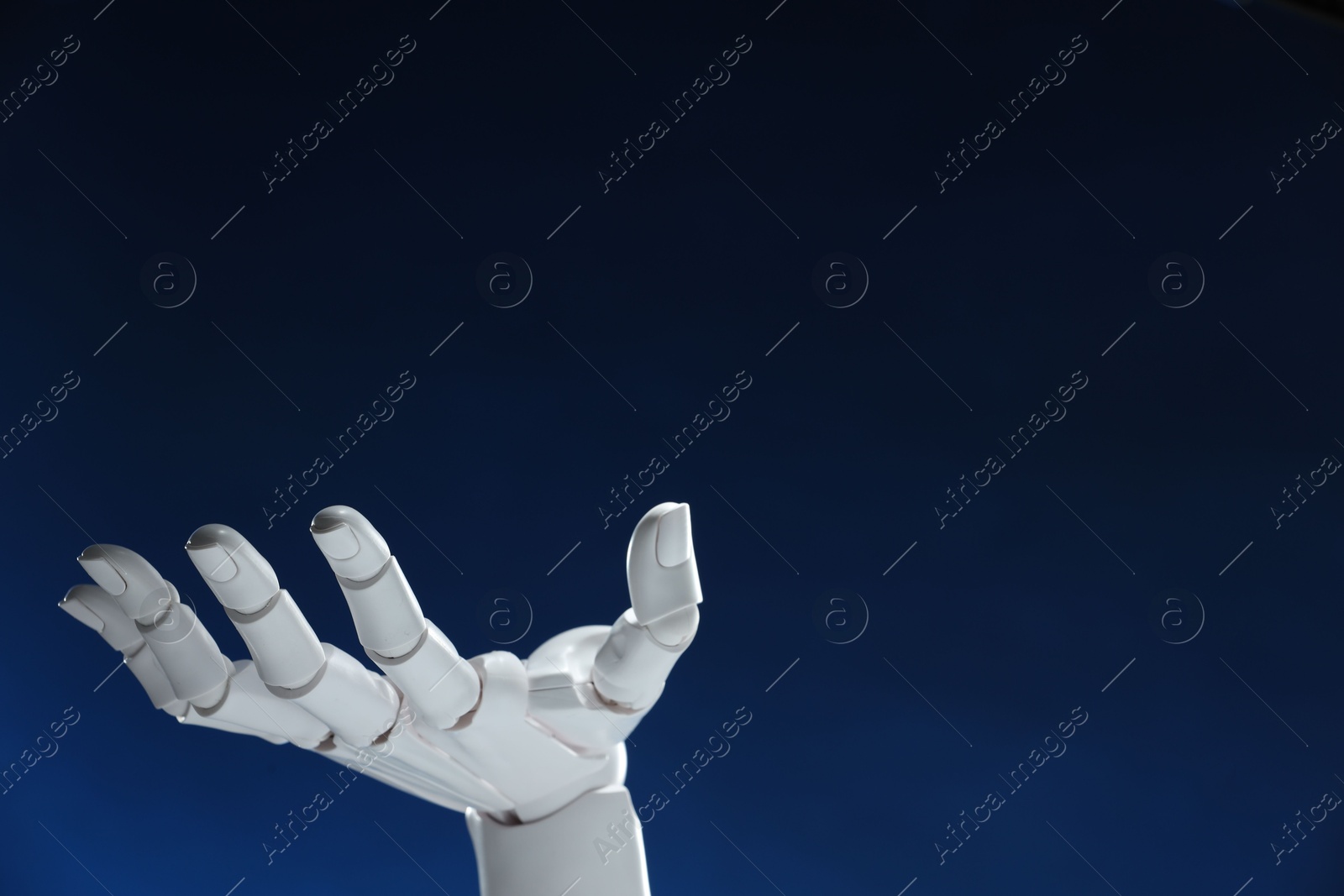 Photo of Artificial intelligence. Robot hand gesturing on dark blue background, space for text