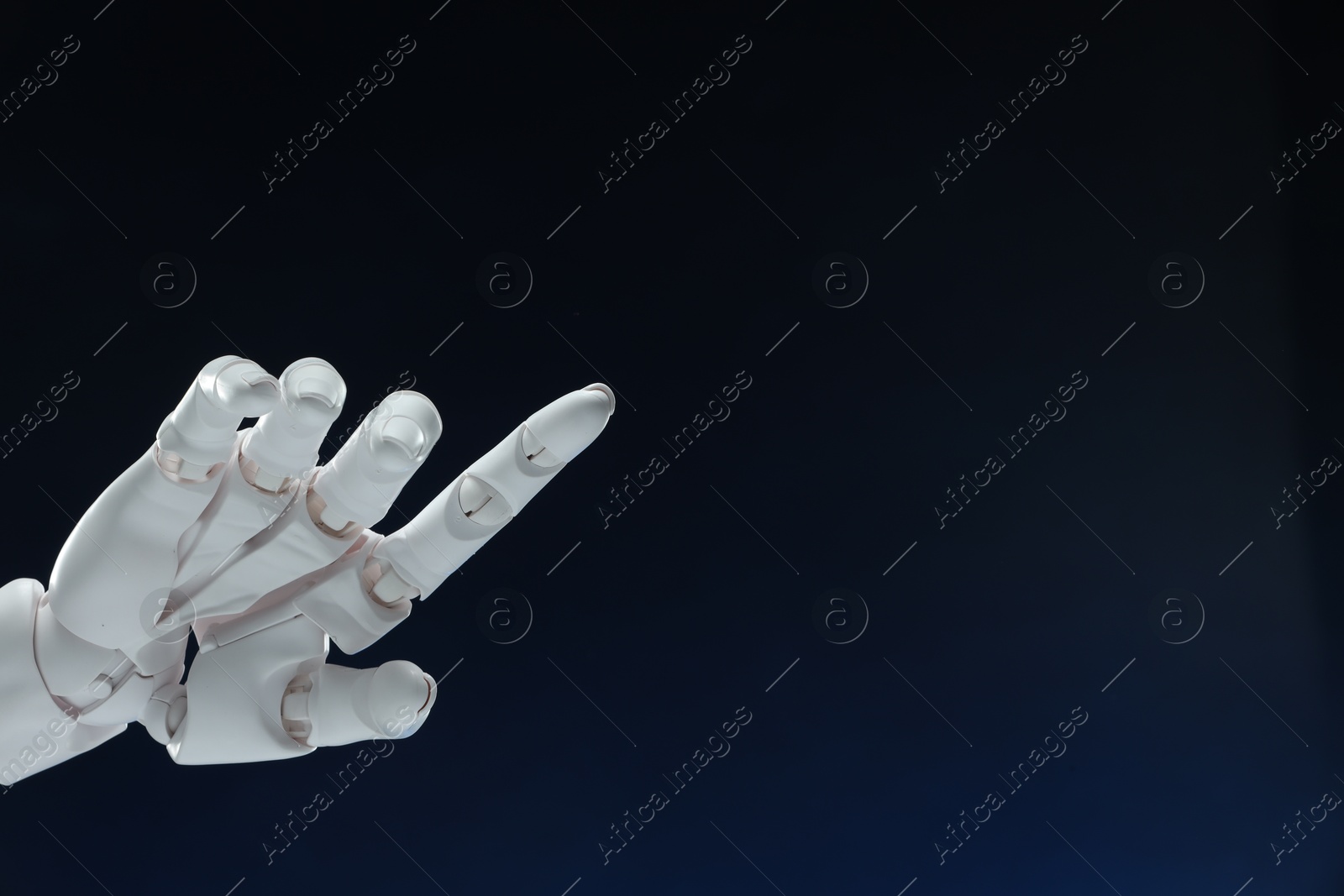 Photo of Artificial intelligence. Robot hand pointing at something on dark blue background, space for text