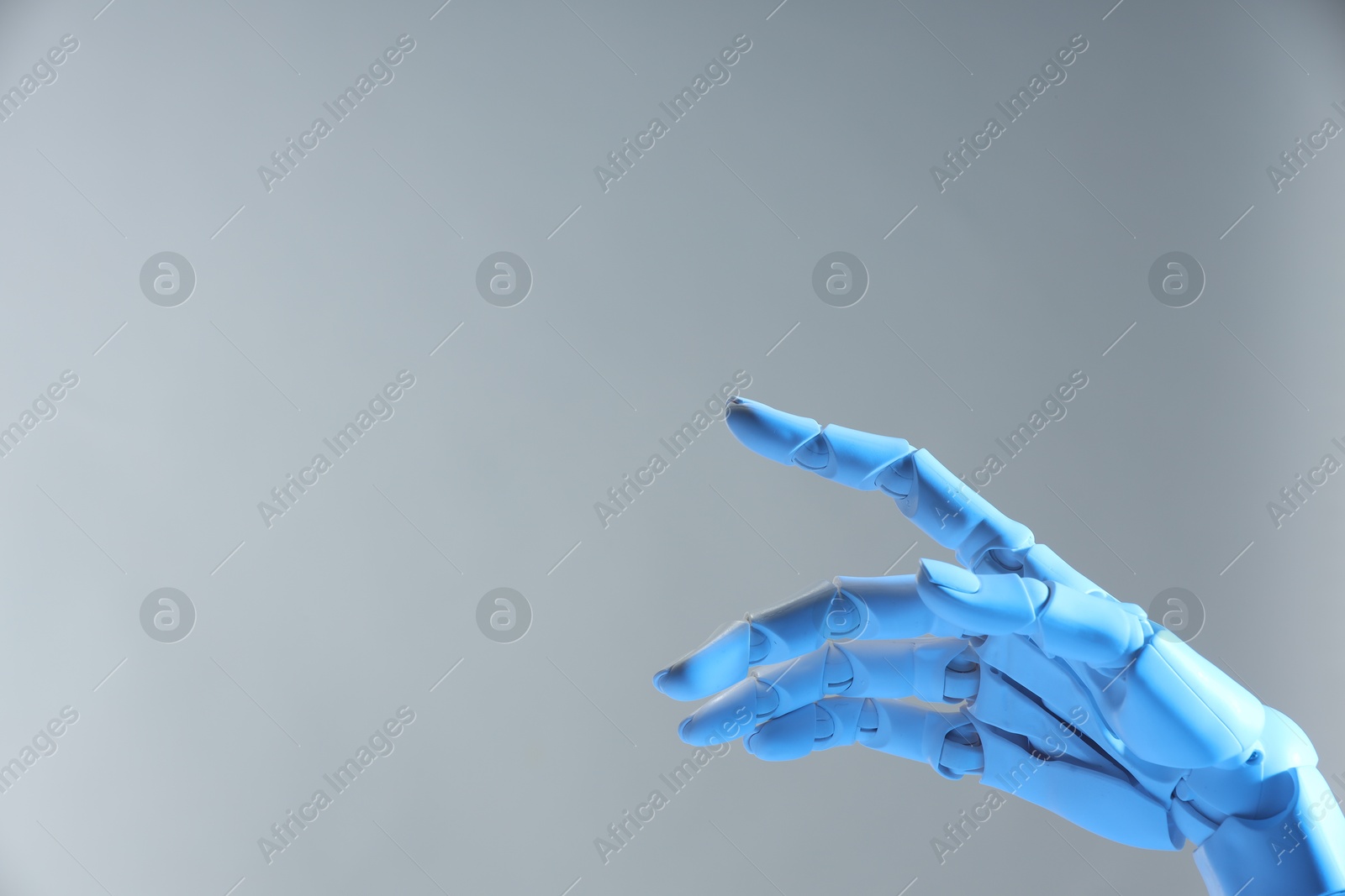 Photo of Artificial intelligence. Robot hand pointing at something on grey background, space for text