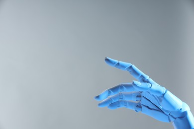 Photo of Artificial intelligence. Robot hand pointing at something on grey background, space for text