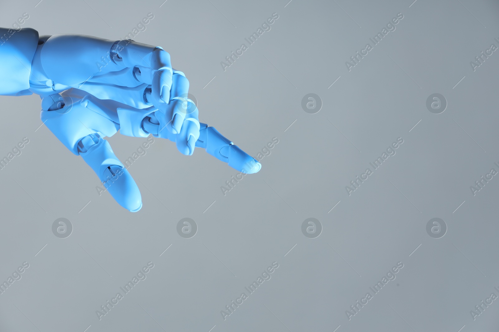 Photo of Artificial intelligence. Robot hand pointing at something on grey background, space for text