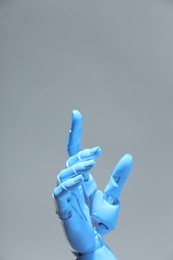 Photo of Artificial intelligence. Robot hand pointing at something on grey background