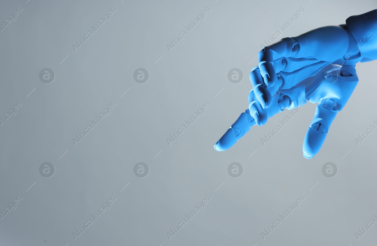 Photo of Artificial intelligence. Robot hand pointing at something on grey background, space for text