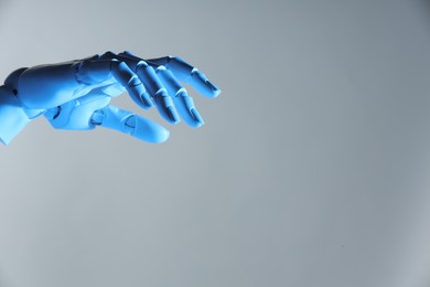 Photo of Artificial intelligence. Robot hand gesturing on grey background, space for text