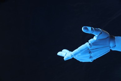 Photo of Artificial intelligence. Robot hand gesturing on dark background, space for text