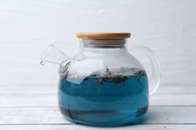 Photo of Delicious butterfly pea flower tea on wooden table against white background