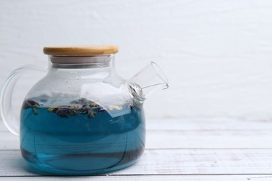 Delicious butterfly pea flower tea on wooden table against white background. Space for text