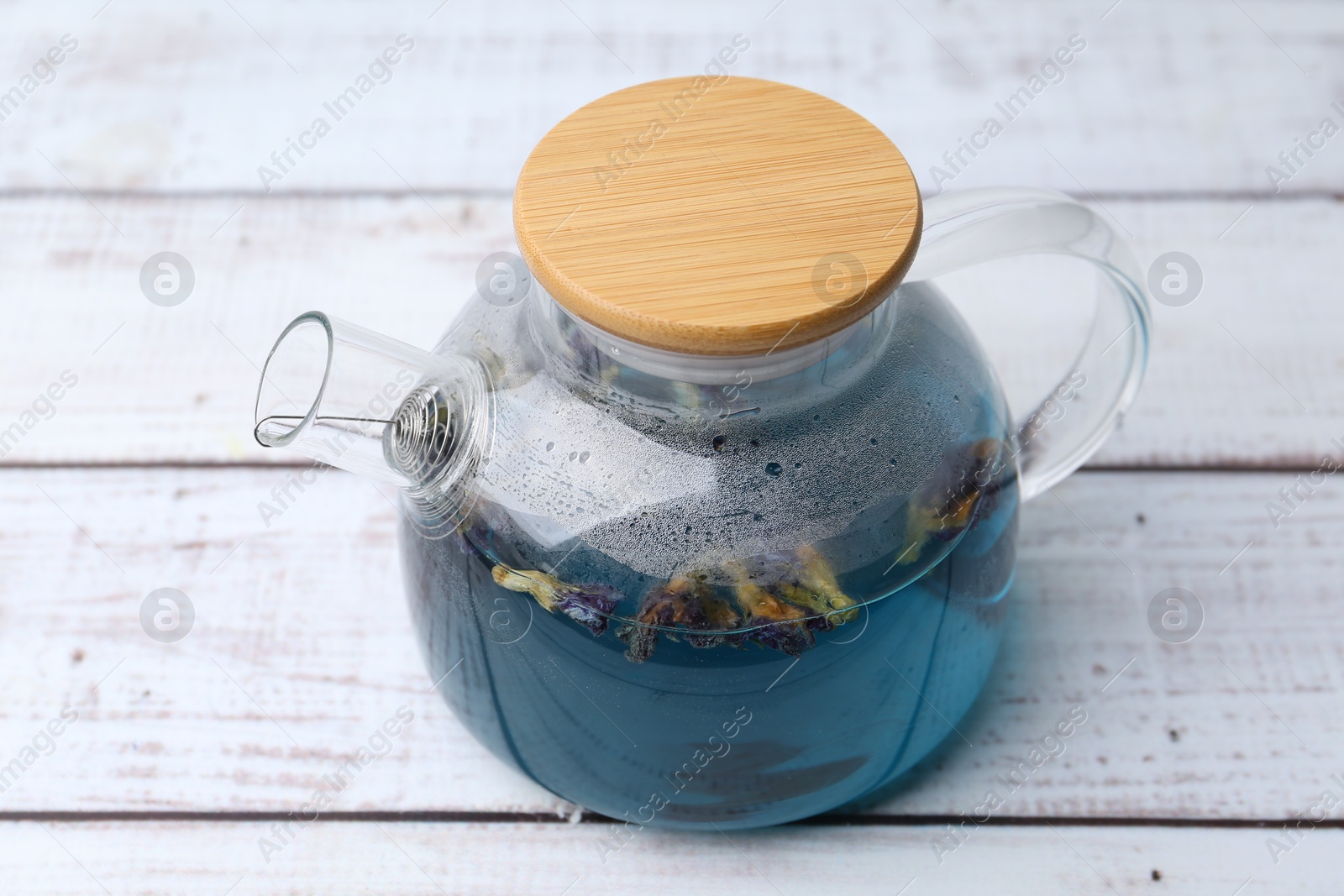 Photo of Delicious butterfly pea flower tea on wooden table, closeup