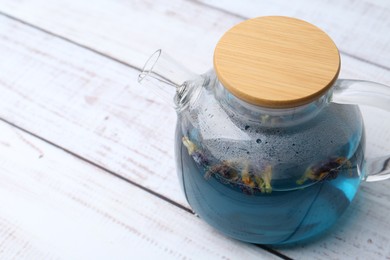 Photo of Delicious butterfly pea flower tea on wooden table, closeup. Space for text