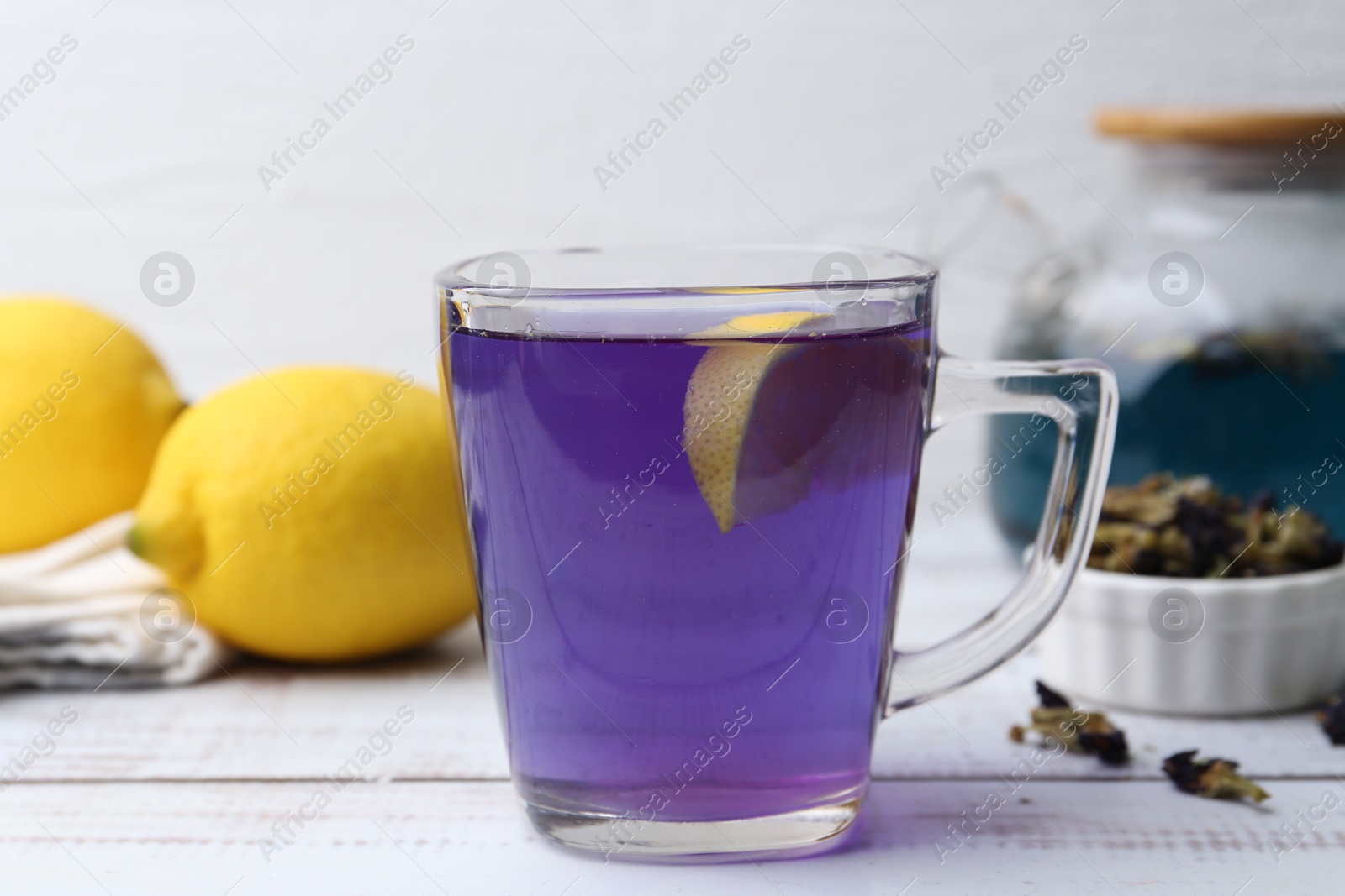 Photo of Delicious butterfly pea flower tea on wooden table against white background