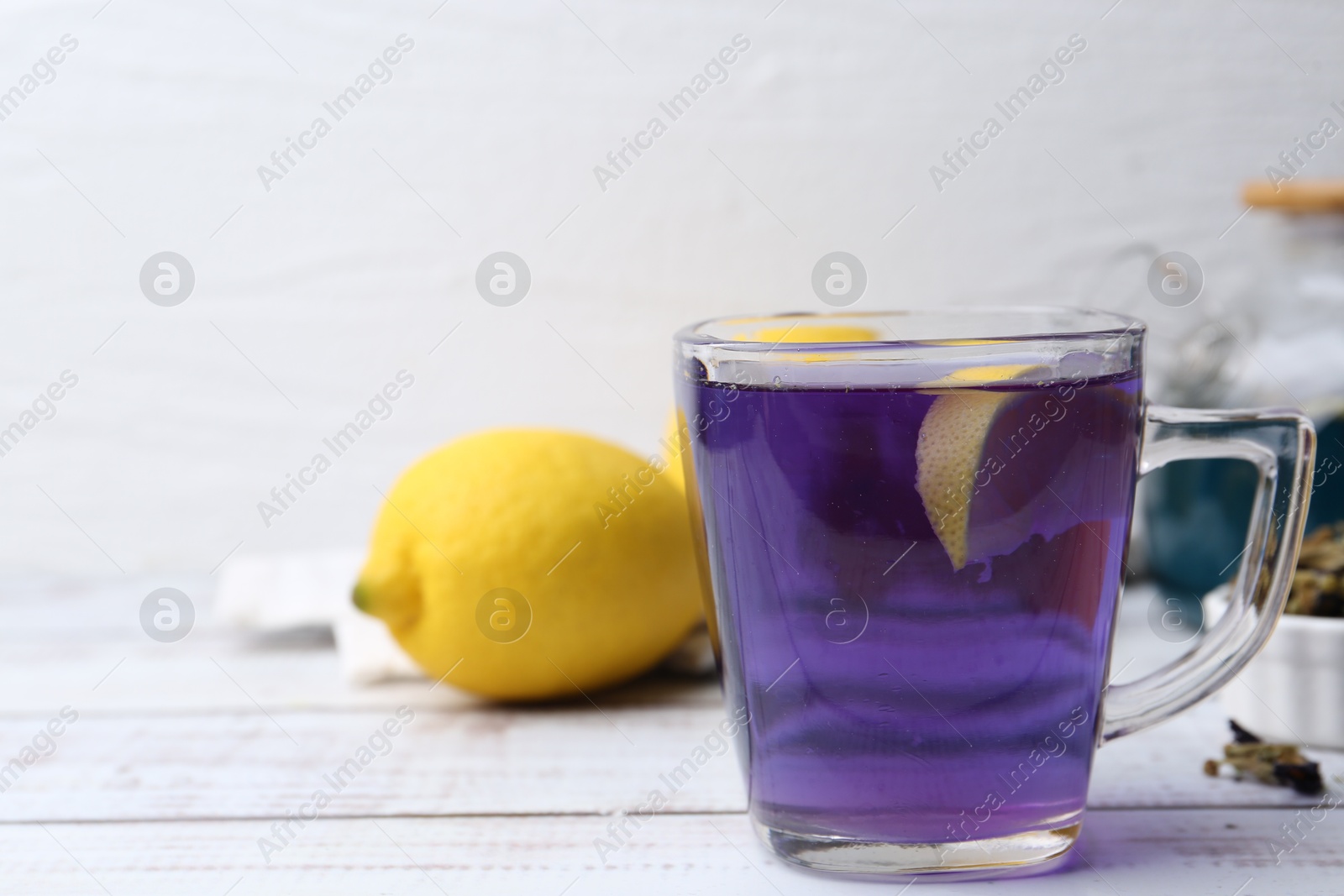 Photo of Delicious butterfly pea flower tea on wooden table against white background. Space for text