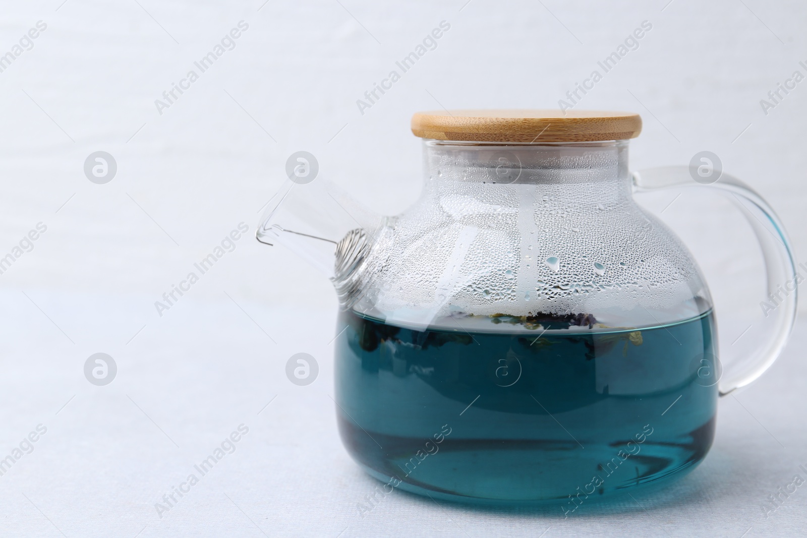 Photo of Delicious butterfly pea flower tea on light table. Space for text