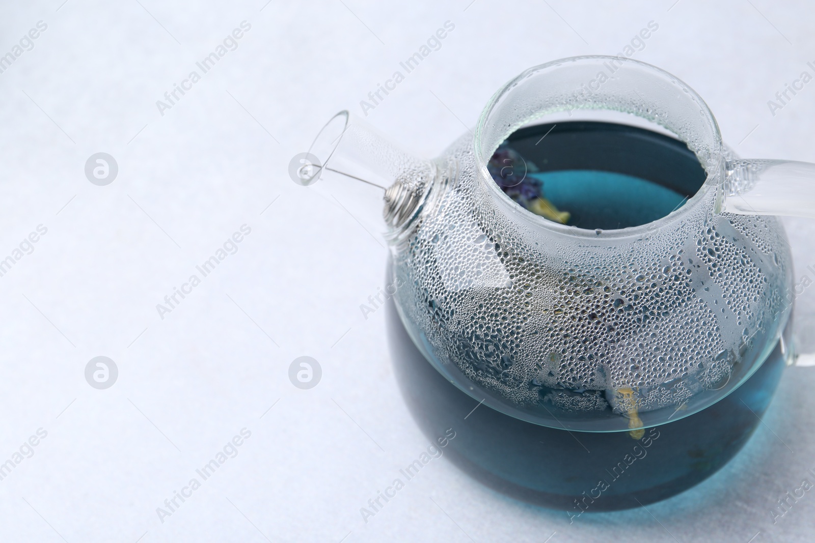 Photo of Delicious butterfly pea flower tea on light table, closeup. Space for text