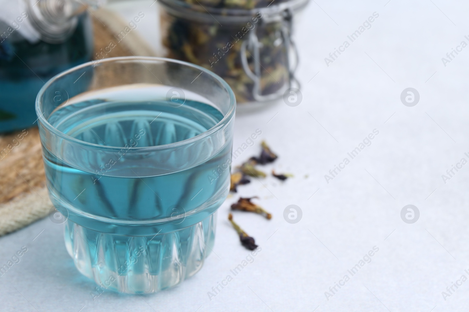 Photo of Delicious butterfly pea flower tea on light table, closeup. Space for text