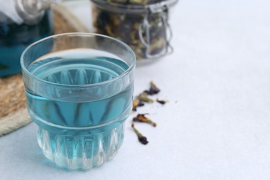 Photo of Delicious butterfly pea flower tea on light table, closeup. Space for text