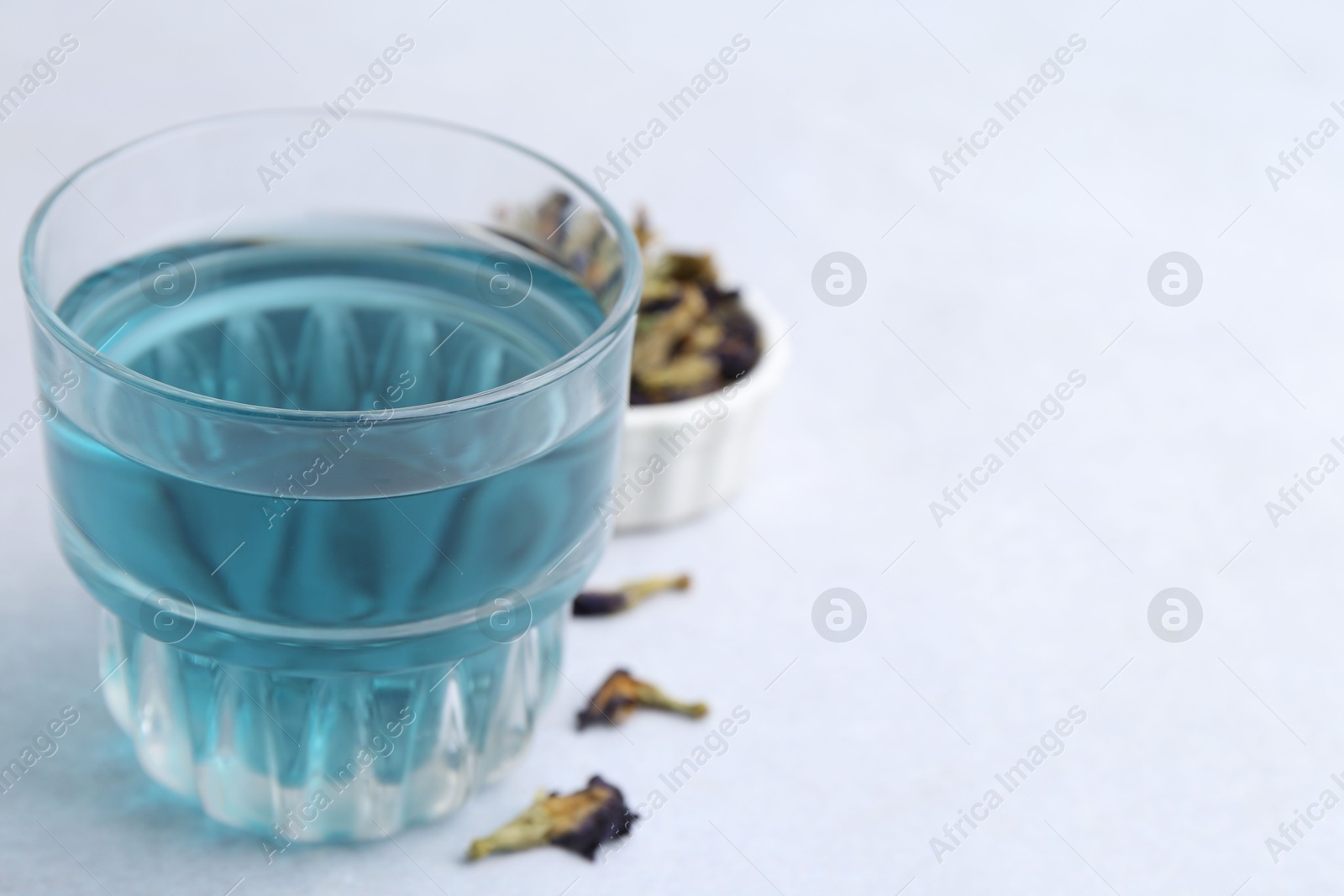 Photo of Delicious butterfly pea flower tea on light table, closeup. Space for text