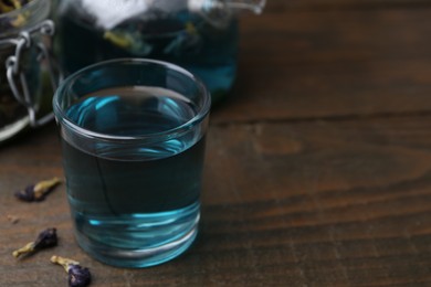 Delicious butterfly pea flower tea on wooden table. Space for text