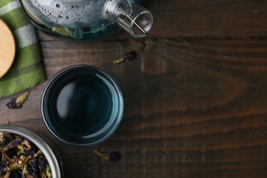 Photo of Delicious butterfly pea flower tea on wooden table, flat lay. Space for text