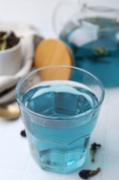 Delicious butterfly pea flower tea on white table, closeup