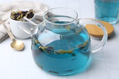 Delicious butterfly pea flower tea on white tiled table, closeup