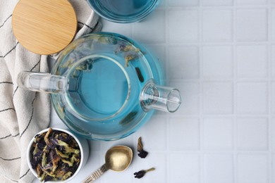 Delicious butterfly pea flower tea on white tiled table, flat lay. Space for text