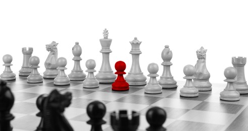 Image of One red chess piece among others on chessboard, black and white effect