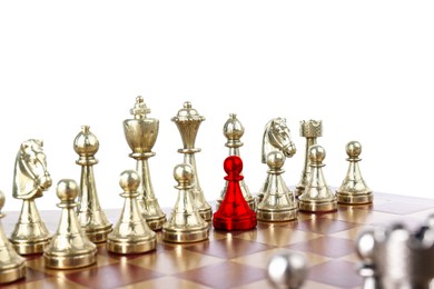 Image of One red pawn among golden chess pieces on wooden chessboard