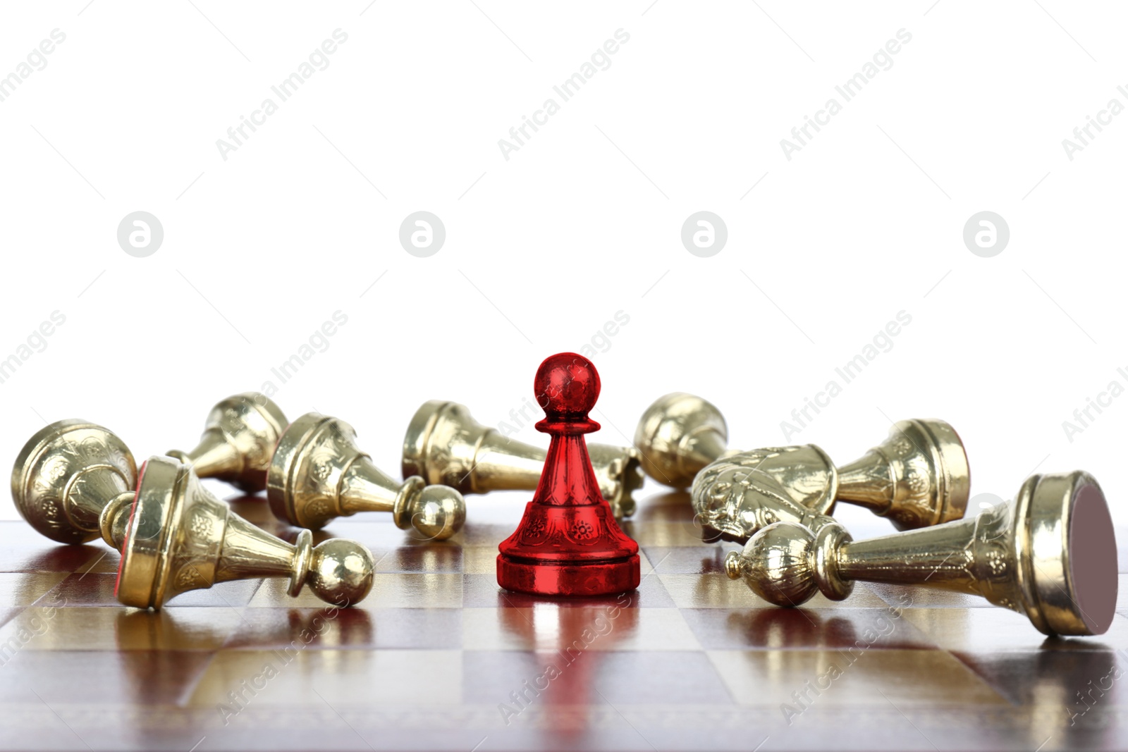 Image of Red pawn standing among lying chess pieces on wooden chessboard