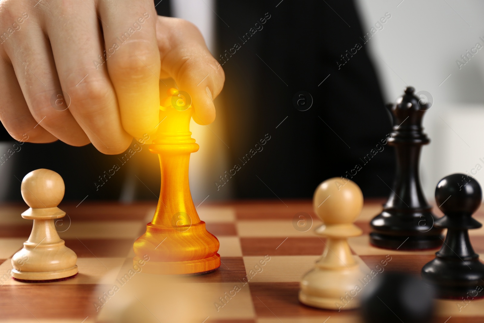 Image of Man making move by placing queen on wooden chessboard, closeup