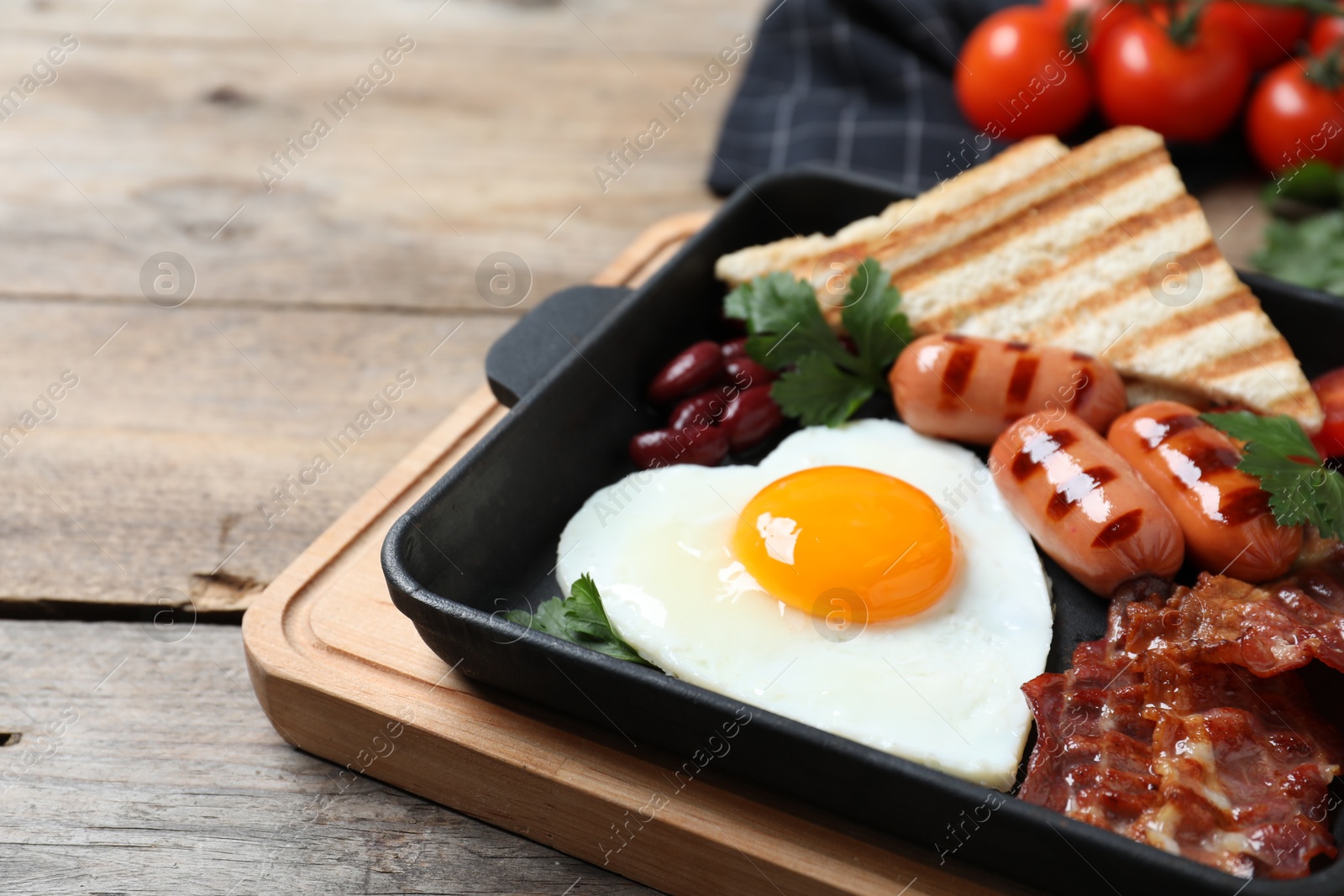 Photo of Tasty breakfast with heart shaped fried egg and  sausages on wooden table, closeup