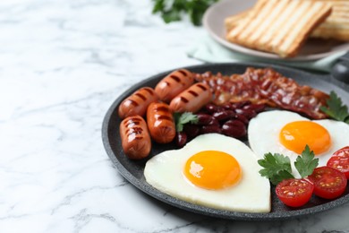 Photo of Delicious breakfast with heart shaped fried eggs and  sausages on white marble table, closeup