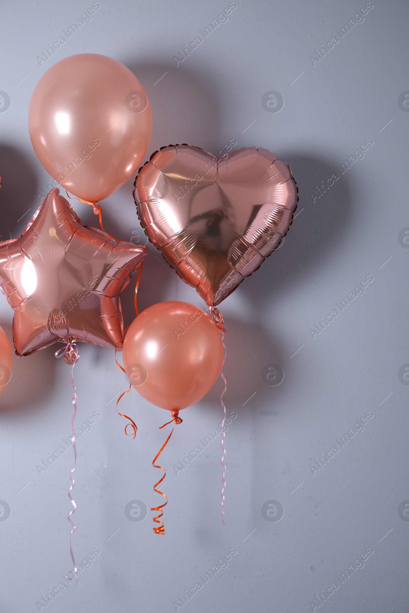 Photo of Different balloons near light wall. Festive decor