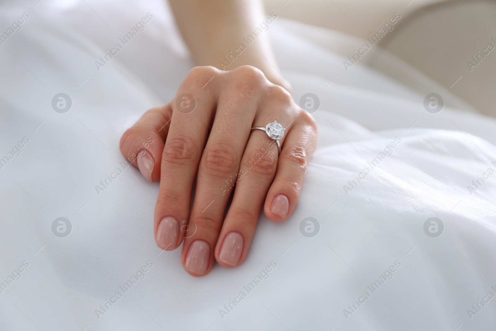 Photo of Young bride wearing beautiful engagement ring, closeup