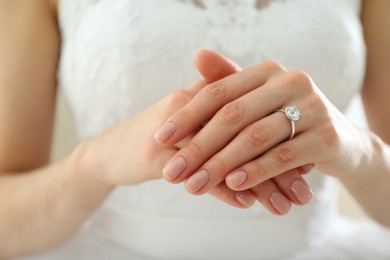 Photo of Young bride wearing beautiful engagement ring, closeup